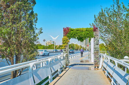 The pedestrian pass on the modern Felezi bridge is decorated with plants and flowers in pots, Isfahan, Iran.のeditorial素材