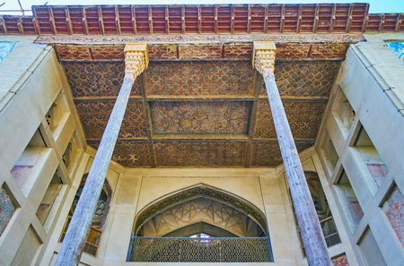 ISFAHAN, IRAN - OCTOBER 20, 2017: The  carved wooden ceiling and slender pillars of the porch of Hasht Behesht Palace, famous for its outstanding decorations, on October 20 in Isfahan.のeditorial素材