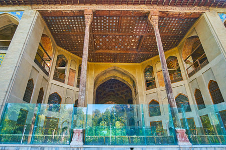 ISFAHAN, IRAN - OCTOBER 20, 2017: The  summer terrace of Hasht Behesht Palace with tall timber columns, arched niches in walls and the carved wooden ceiling, decorated with mirrors, on October 20 in Isfahan.のeditorial素材