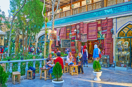 ISFAHAN, IRAN - OCTOBER 20, 2017: The small outdoor cafe in courtyard of Grand Bazaar is neighboring with carpet store, on October 20 in Isfahan.のeditorial素材