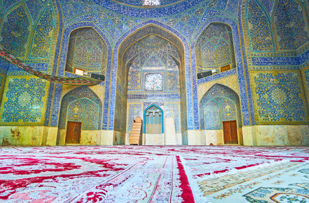 ISFAHAN, IRAN - OCTOBER 20, 2017: The prayer hall of the old mosque in Chaharbagh madraseh, the walls are decorated with fine patterns and Arabic calligraphy of glazed tile, on October 20 in Isfahan.のeditorial素材