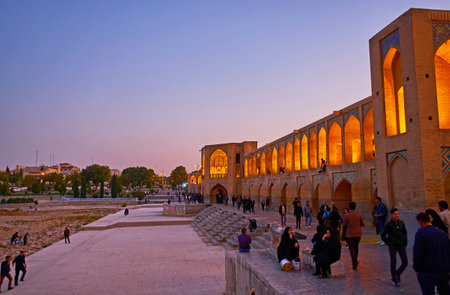 ISFAHAN, IRAN - OCTOBER 20, 2017: The terrace in front of  Khaju bridge is crowded place in the evening, locals enjoy their free time here, on October 20 in Isfahan.のeditorial素材