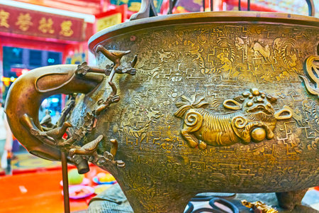 YANGON, MYANMAR - FEBRUARY 14, 2018: Relief patterns on bronze vase for insence sticks in Chinese Guanyin Gumiao Temple of Chinatown, on February 14 in Yangon.のeditorial素材