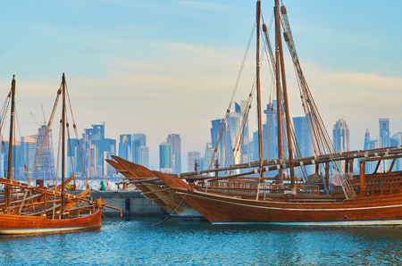 The numerous skyscrapers of Al Dafna district, covered with sunrise beams, are seen through the old...