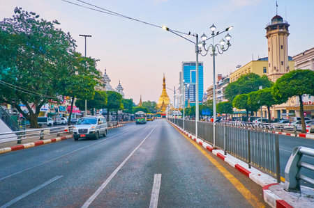 YANGON, MYANMAR - FEBRUARY 16, 2018: The early morning in Downtown - almost empty Sule road with the huge golden stupa of Sule Paya on background, on February 16 in Yangon.のeditorial素材