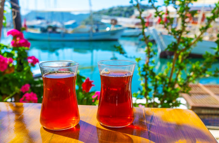 Two glasses of Turkish black tea on the table of nice outdoor cafe on the coast of Mediterranean sea, Kekova, Turkey.のeditorial素材