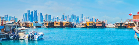 Panorama of the harbor with numerous dhows and row of futuristic skyscrapers of West Bay  on the background, Doha, Qatar.の写真素材