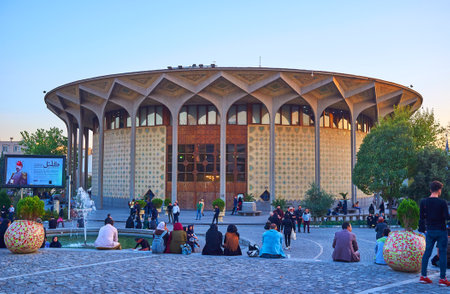 TEHRAN, IRAN - OCTOBER 24, 2017: Locals enjoy their evening time in Daheshgu Park with a view on beautiful edifice of Teatre Shahr built in persian style, on October 24 in Tehran.のeditorial素材