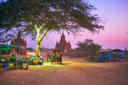 BAGAN, MYANMAR - FEBRUARY 24, 2018: The horse carriages are traditional transport on dusty trails in Bagan archaeological park, on February 24 in Baganのeditorial素材