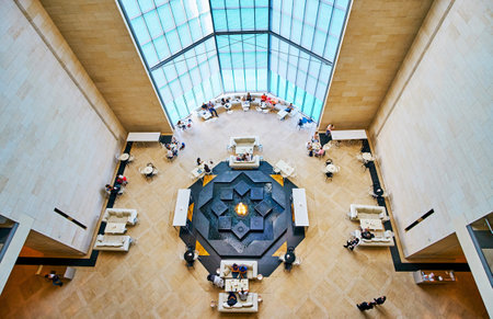 DOHA, QATAR - FEBRUARY 13, 2018: The top view of the hall in Islamic Art Museum with scenic stone fountain, decorated with carved stars and surrounded by cafe tables, on February 13 in Doha.のeditorial素材