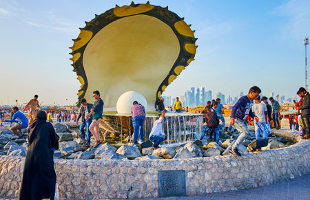 DOHA, QATAR - FEBRUARY 13, 2018: People make selfies and watch the Pearl fountain, located on Corniche Promenade, on February 13 in Doha.のeditorial素材