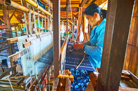 INLE LAKE, MYANMAR - FEBRUARY 18, 2018: Producing of silk textile on the old traditional hand loom in workshop, located  on Inle lake in Inpawkhon village, on February 18 in Inle lake.のeditorial素材
