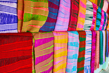 The close-up view of traditional scarfs, made in authentic workshop by Padaung Kayan women (long neck women), the bright colored peaces decorated with geometric patterns, Ywama village, Inle Lake, Myanmar.の写真素材
