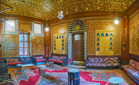 CAIRO, EGYPT - DECEMBER 24, 2017: The carved wooden salon with golden patterns and niches for...