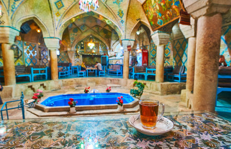 KERMAN, IRAN - OCTOBER 15, 2017: The cup of traditional Persian tea on the table in Vakil restaurant and teahouse, located in building of the former bath with splendid historical interior, on October 15 in Kerman.のeditorial素材