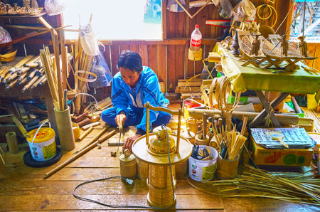INPAWKHON, MYANMAR - FEBRUARY 18, 2018: The Burmese worker produces traditional bamboo souvenirs in workshop-store on Inle lake, on February 18 in Inpawkhon.のeditorial素材