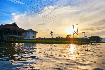 The cloudy sunset sky over the medieval village on Inle Lake, Ywama, Myanmar.の写真素材