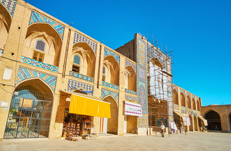KERMAN, IRAN - OCTOBER 15, 2017: The facade of Ganjali Khan Caravanserai with stalls and workshops, tiled iwan (portal) and arched niches - traditional detail of medieval Persian architecture, on October 15 in Kerman.のeditorial素材