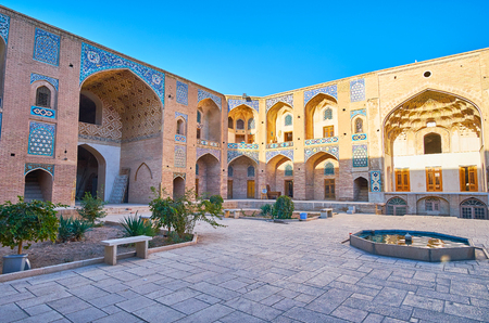 Relax in tiny garden of Ganjali Khan Caravanserai - historical building with preserved medieval architecture, masterpiece tilework and muqarnas (honeycomb) arches, Kerman, Iran.の写真素材