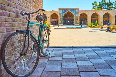 The view on Ganjali Khan Square with parked bicycle on the foreground, Kerman, Iran.の写真素材