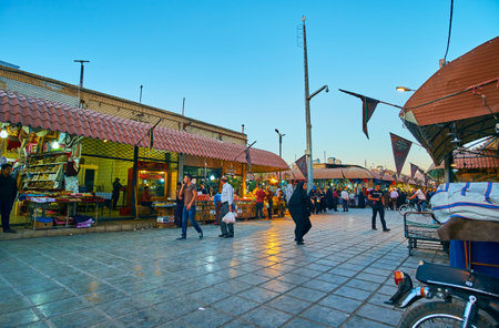 KERMAN, IRAN - OCTOBER 15, 2017: The evening street of Ganjali Khan Bazaar with illuminated stalls, offering different goods and attracting people with low prices, on October 15 in Kerman.のeditorial素材