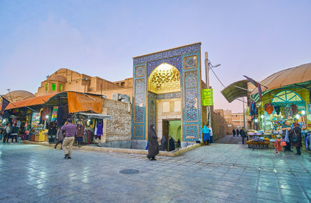 KERMAN, IRAN - OCTOBER 15, 2017: The portal of Friday (Jame) Mozaffari Mosque faces the market street with noisy stalls, full of different goods, on October 15 in Kerman.のeditorial素材