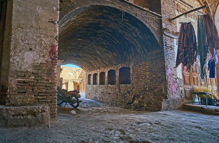 The shabby brick pass leads to the historical Hindu Caravanserai, located alongside the old Sartasari Bazaar, Kerman, Iran.の写真素材