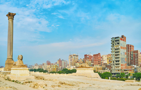 Panorama with Pompey's Triumphal Pillar and two sphinxes, standing on ruins of ancient Greek Serapeum Temple, dedicated to Serapis - the patron of Alexandria, Egypt.の写真素材