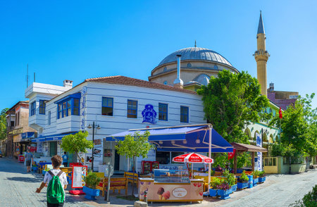 ANTALYA, TURKEY - MAY 11, 2017: The dome and minaret of Imaret Mosque with restaurants and ice cream cafe on th foreground, on May 11 in Antalya.のeditorial素材