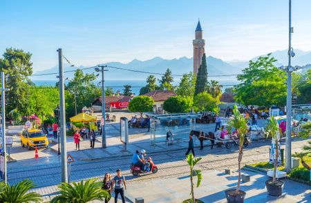 ANTALYA, TURKEY - MAY 11, 2017: The busy Republic street with horse carriages, tall minaret of Alaaddin mosque (Yivliminare) and foggy Taurus mountains on background, on May 11 in Antalya.のeditorial素材