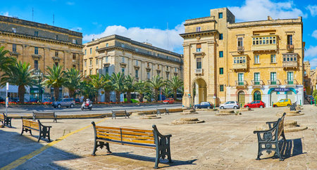 FLORIANA, MALTA - JUNE 17, 2018: Panorama of Robert Samut square with capstones of granaries in the middle, surrounded by row of benches and St Anne avenue on background, on June 17 in Floriana.のeditorial素材