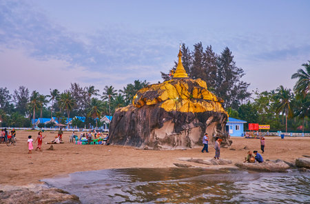 CHAUNG THA, MYANMAR - FEBRUARY 28, 2018: The sunset coast of Bengal Bay with a view on Kyauk Pa Hto Pagoda, covered with gilt and surrounded by street vendors and tourists, on February 28 in Chaung Tha.のeditorial素材