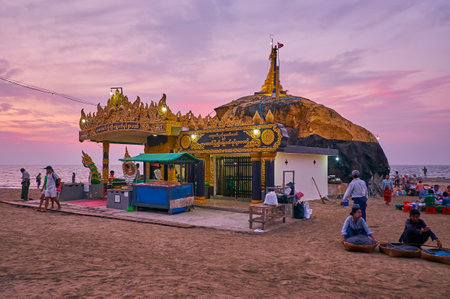 CHAUNG THA, MYANMAR - FEBRUARY 28, 2018: The scenic sunset view of Kyauk Pa Hto Pagoda with carved patterns, pillars and Naga-Raja, sculptures, on February 28 in Chaung Tha.のeditorial素材