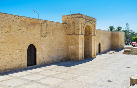 The horseshoe arch of the Grand Mosque's gateway, surrounded by massive medieval defensive rampart,...