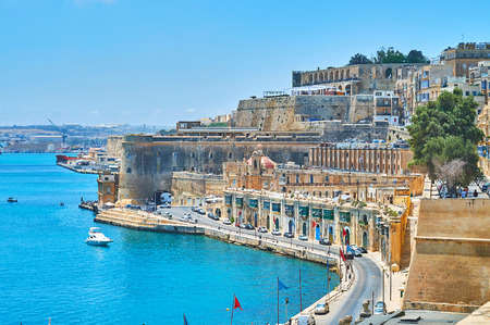 The fortress walls of Valletta open the perfect view on Quarry Wharf with medieval buildings,...