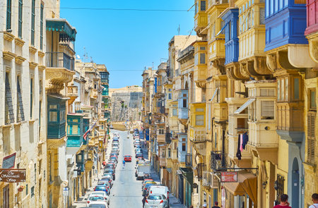 VALLETTA, MALTA - JUNE 17, 2018: The descent in Republic street, lined with historical residential edifices, with a view on massive rampart of Fort Saint Elmo on the distance, on June 17 in Valletta.のeditorial素材