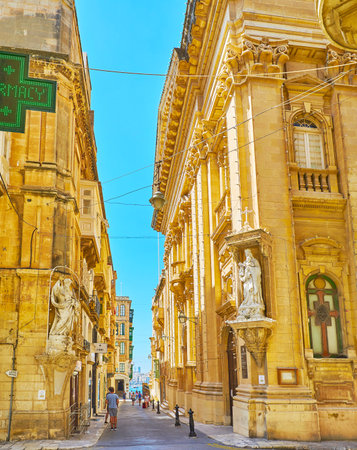 VALLETTA, MALTA - JUNE 17, 2018: The intersection of Old Theatre and Old Mint streets with corner statues of St Elias and Our Lady of Mount Carmel, on June 17 in Vallettaのeditorial素材