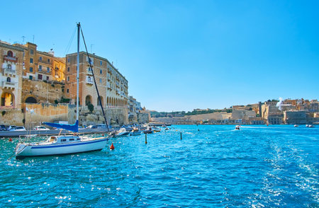 The view from Vittoriosa marina on the old stone buildings of Senglea (L-Isla), boats and yachts at its shore and the huge ramparts of Valletta on the distance, Malta.のeditorial素材