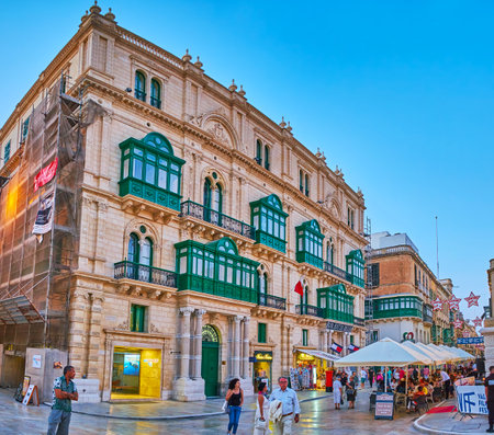 VALLETTA, MALTA - JUNE 17, 2018: The evening walk in the city center with a view on scenic edifices, decorated with colorful wooden Maltese balconies, Republic street, on June 17 in Valletta.のeditorial素材