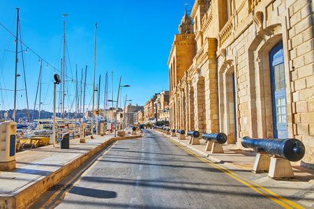 The vintage cannons along the wall of Maritime museum in Xatt Il-Forn promenade, facing Vittoriosa marina with yachts and boats, Birgu, Malta.のeditorial素材