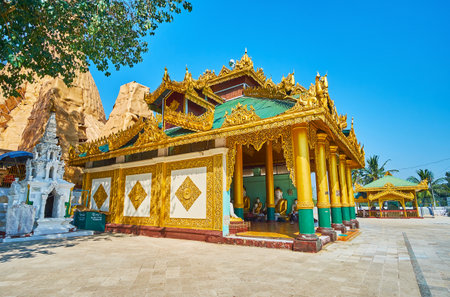 YANGON, MYANMAR - FEBRUARY 27, 2018: The territory of Shwedagon Pagoda with scenic pavilions, golden stupas and carved image house with statues of Lord Buddha, on February 27 in Yangon.のeditorial素材