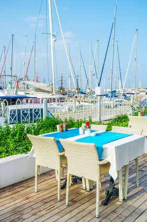 The scenic outdoor cafe, located in marina of Kemer and boasts the view on white sailing yachts, Turkey.のeditorial素材