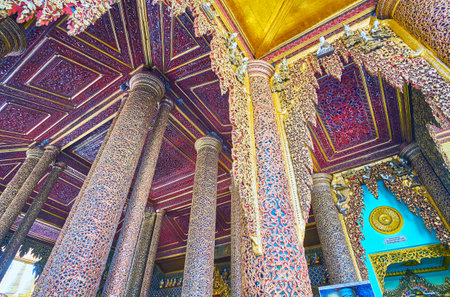 YANGON, MYANMAR - FEBRUARY 27, 2018: The intricate carved pattern with mirror inlay on columns and ceiling panels of Gautama Buddha Image House in, Shwedagon Zedi Daw, on February 27 in Yangonのeditorial素材