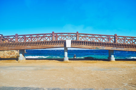 The scenic wooden bridge stretches along the coast of Dahab, the stormy waters of Aqaba Gulf are seen behind it, Sinai, Egypt.のeditorial素材