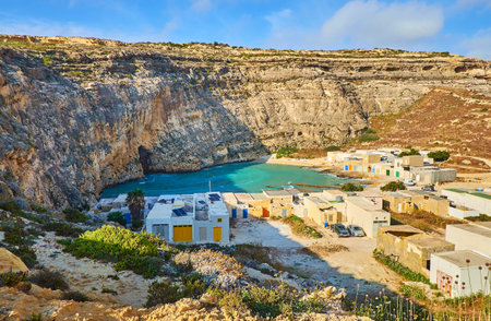 The top of the rocky cliff is the best place to overlook the small San Lawrenz fishing village, located on shore of Dwejra Inland Sea, Gozo Island, Malta.のeditorial素材