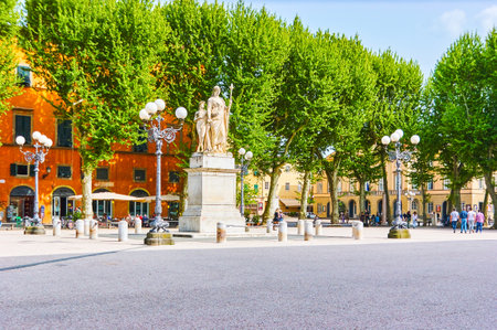 LUCCA, ITALY - APRIL 30, 2013: The scenic Piazza Napoleone with surrounded lush trees is a very popular place for resting and visiting local cafes, on April 30 in Luccaのeditorial素材