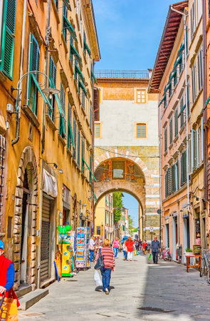LUCCA, ITALY - APRIL 30, 2013: The popular tourist shopping street Via Santa Croce with restored medieval Porta San Gervasio Gates on its end, on April 30 in Luccaのeditorial素材