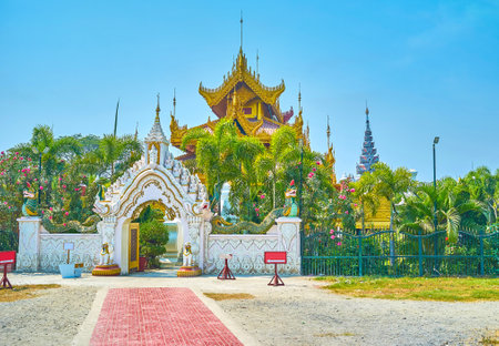 The arched gates leads to the huge shrine with golden roof and surrounded with lush greenery of Kyauktawgyi Pagoda's garden, Mandalay, Myanmarのeditorial素材