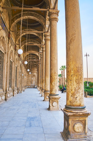The huge building of Alabaster Mosque is surrounded by long arcades with multiple domes, slender columns and lamps on chains, Saladin Citadel, Cairo, Egypt.のeditorial素材