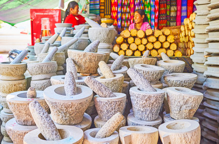 SAGAING, MYANMAR - FEBRUARY 21, 2018: Stall of Kaunghmudaw Pagoda market with kyauk pyin mortars and...